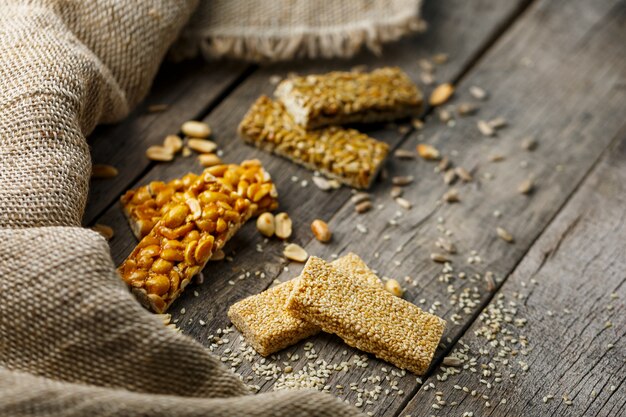 Geassorteerde kozinaki ,, met jute stof. landelijke stijl. heerlijke zoetigheden van de zaden van zonnebloem, sesam en pinda's, bedekt met glanzend glazuur.