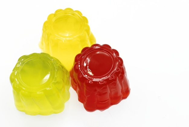 Geassorteerde rode, groene en gele gelatine geïsoleerd op witte aardbei citroen limoen gelatine smaken