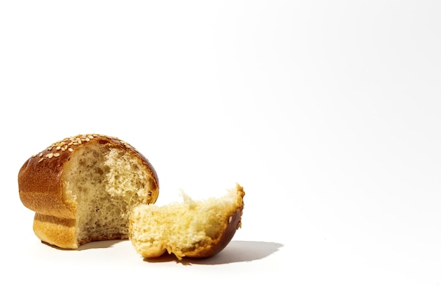 Geassorteerde ronde zelfgemaakte briochebroodjes met zaden op een witte achtergrond met hoog contrastlicht. Geïsoleerd