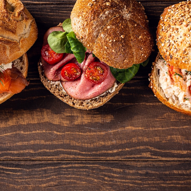 Geassorteerde sandwiches op houten oppervlak. Gezond voedselconcept met exemplaarruimte. Bovenaanzicht