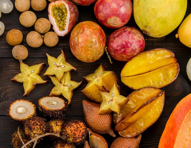 Geassorteerde Thaise tropische vruchten op een donkere houten rustieke achtergrond.