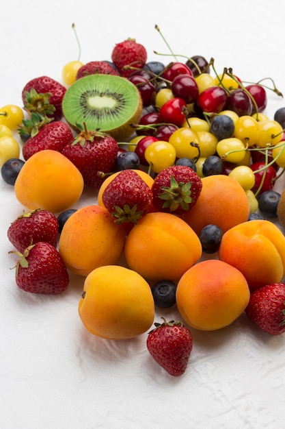 Geassorteerde verse bessen en fruit. Abrikozen Kiwi Aardbei Kers Bosbes op wit