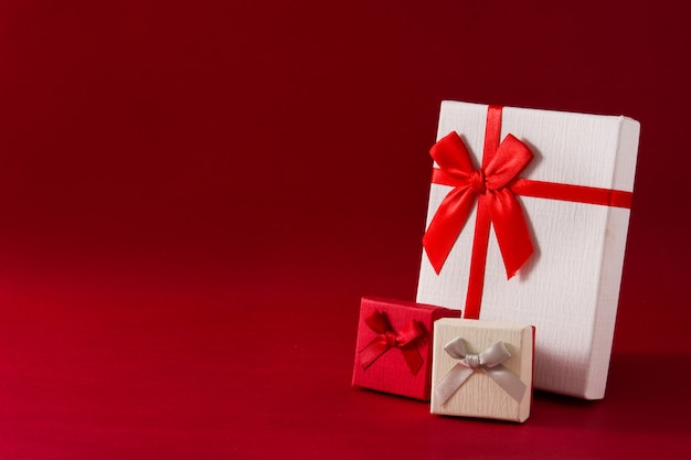 Geassorteerde witte geschenkdozen op rode achtergrond Exemplaarruimte
