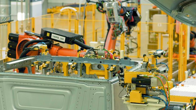 Geautomatiseerde montage van auto's op fabriekslocatie geautomatiseerde machines monteren metalen structuren op de onderneming