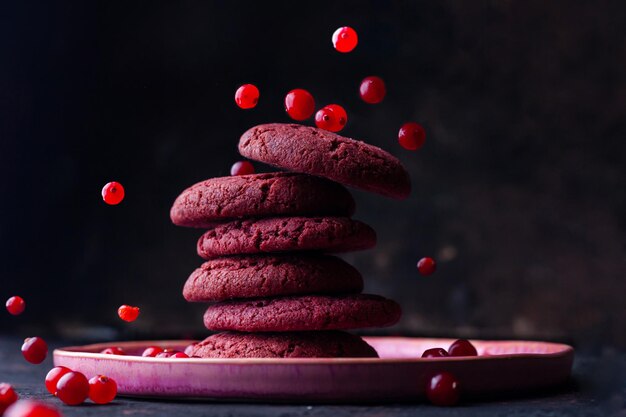 gebak smakelijke koekjes op een donkere achtergrond met vliegende veenbessen op een donkere achtergrond