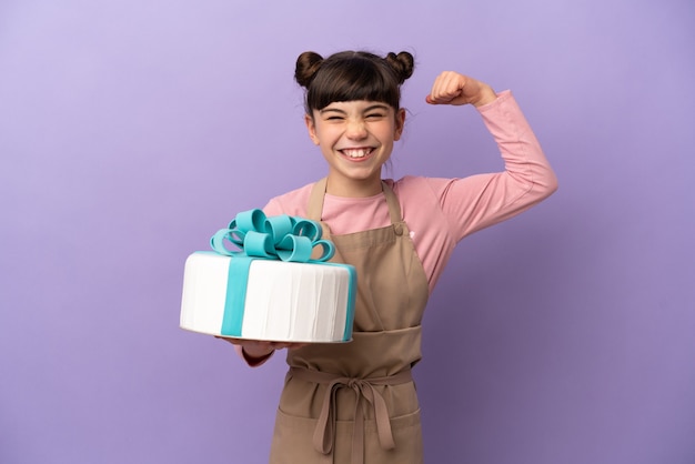 Gebakje meisje die een grote cake houden die op purpere muur wordt geïsoleerd die sterk gebaar doet