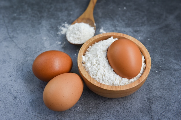 Gebakjebloem op de houten eieren die van de kom eigengemaakte bloem op keuken koken