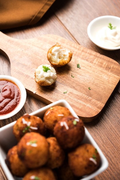 Gebakken aardappel-kaasballetjes of kroketten met tomatenketchup. Selectieve focus