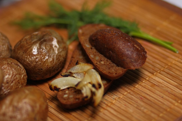 Gebakken aardappelen en donker brood op houten ondergrond. dorps eten