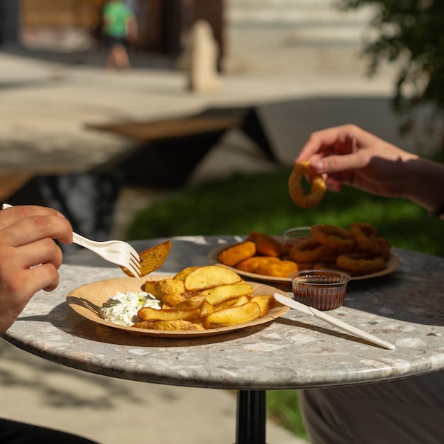 Gebakken aardappelen en uienringen op een bord fastfood straatvoedsel