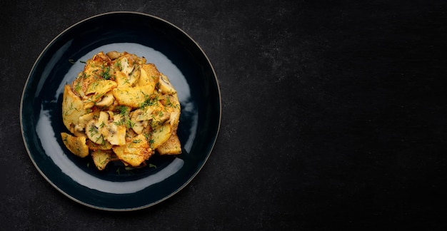 Gebakken aardappelen met champignons en kruiden op een bord