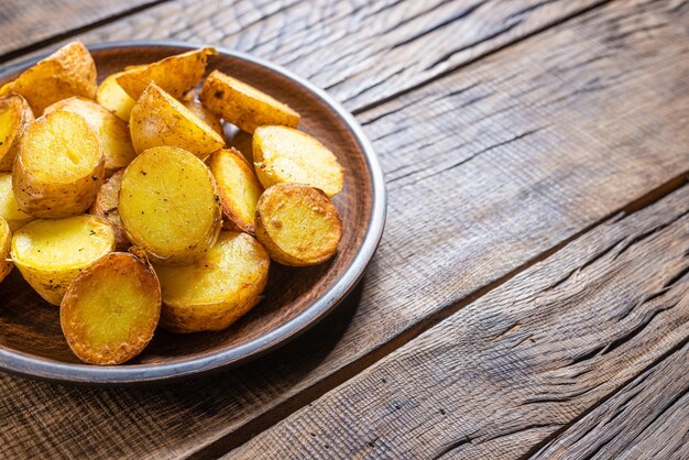 Gebakken aardappelpartjes op een donkere houten achtergrond