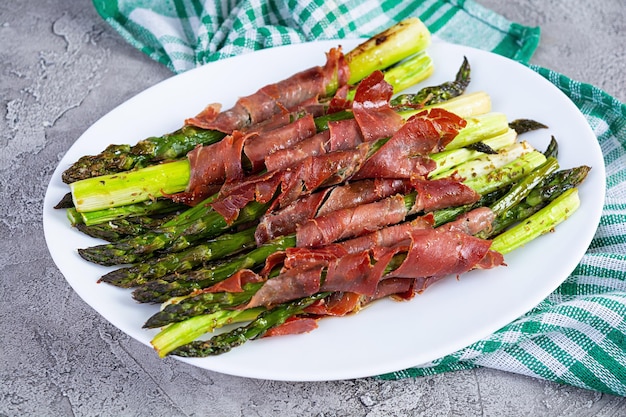 Gebakken asperges met spek en kruiden op houten achtergrond