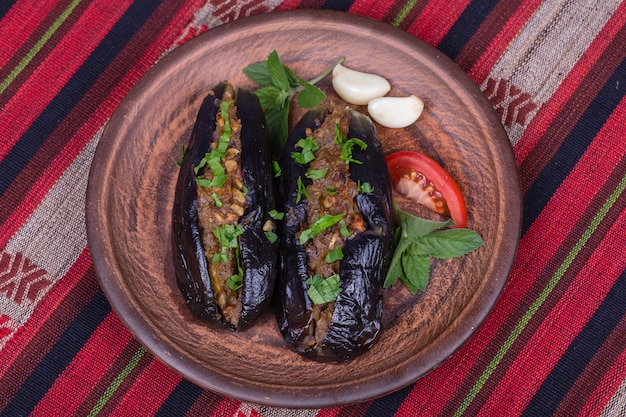 Gebakken aubergine gevuld met uien, kersenpruimen en walnoten op de plaat close-up