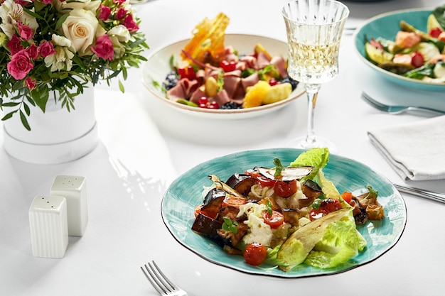 Gebakken aubergines met kaas op tafel omringd door andere Italiaanse gerechten banket tafel lichte tafelkleden