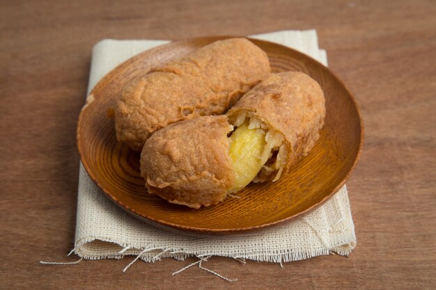 Gebakken bananen in houten plaat op wit linnen, Kluay Tod - Thais dessert.