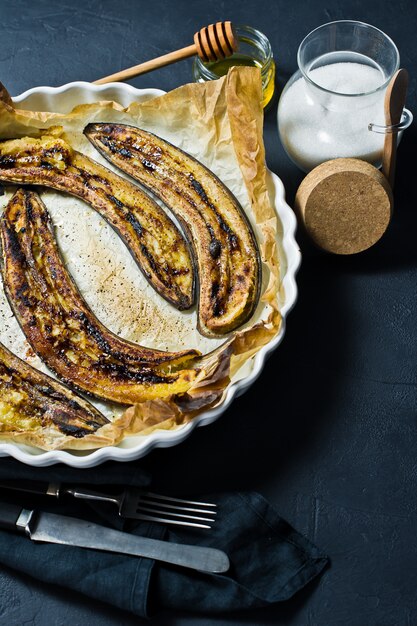 Gebakken bananen met honing in een ovenschaal.