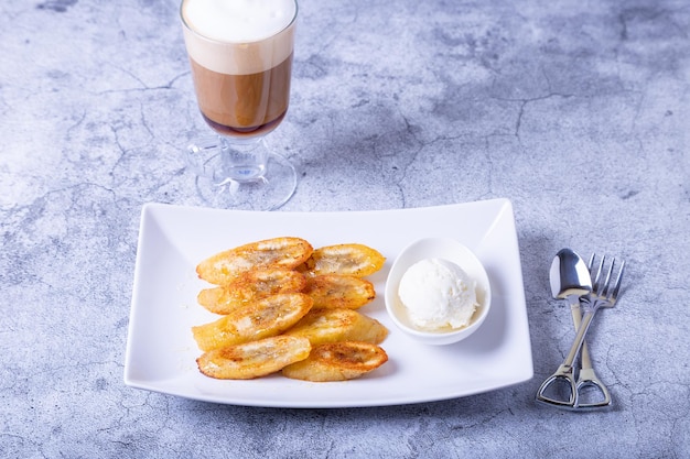 Gebakken bananen met honing kaneel koffie en ijs Closeup