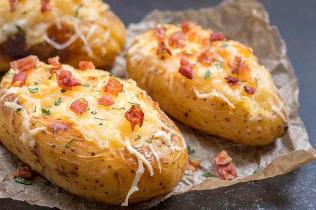 Foto gebakken beladen aardappel met spek, kaas en ui