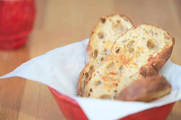 Gebakken brood in rode kom in de houten tafel, ontbijt