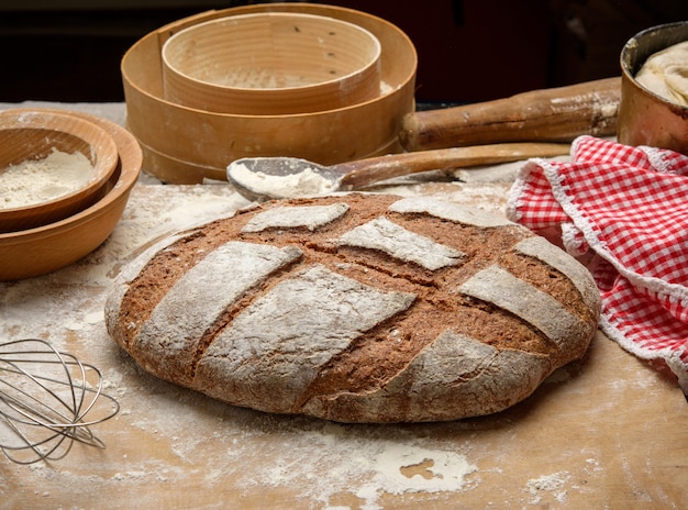 Gebakken brood op tafel en ingrediënten, keukengerei ligt vlakbij, bovenaanzicht