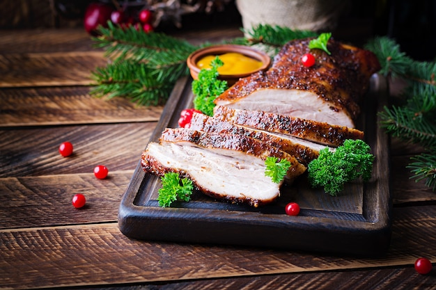 Gebakken buikspek met kruiden. Gekookt varkensvlees. Feestelijke kersttafel.