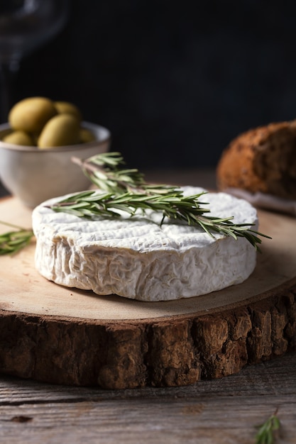 Gebakken camembertkaas met rozemarijn, olijven en brood, selectieve aandacht