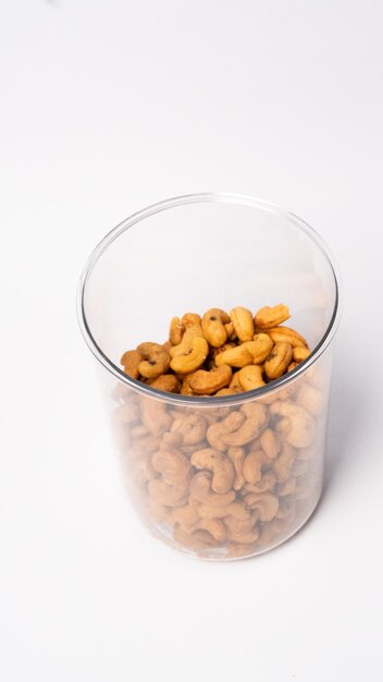 Foto gebakken cashewnoten geïsoleerd op een pot op witte achtergrond