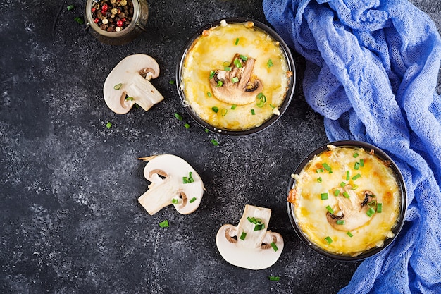 Gebakken champignon Julienne met kip en kaas in potten. Bovenaanzicht