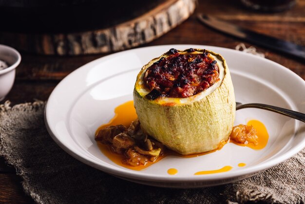 Gebakken courgette gevuld met gemalen vlees en kruiden op een bord