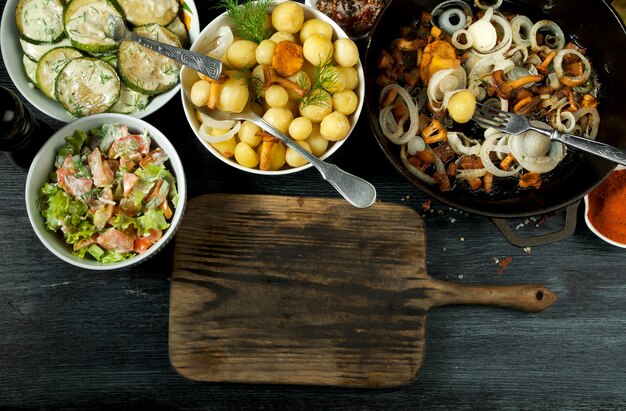 Gebakken courgette, jonge gekookte aardappelen met dille en gefrituurde cantharelpaddestoelen met gouden uien