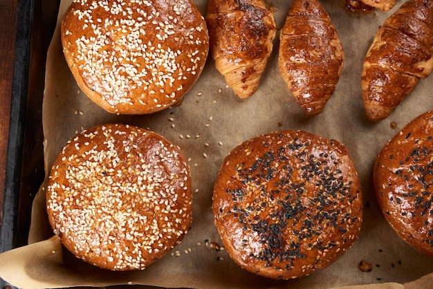 Gebakken croissants en ronde broodjes met sesamzaadjes