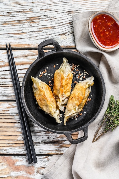 Gebakken dumplings in een pan, Chinees eten koken. Witte achtergrond. Bovenaanzicht.