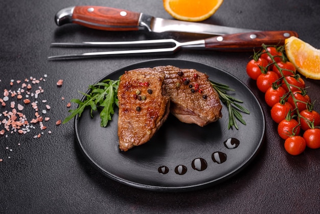 Gebakken eendenborst met kruiden en specerijen op een donkere tafel. Gefrituurd vlees klaar om te eten