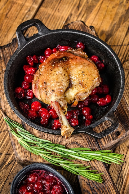 Gebakken eendenbout met cranberriesaus in een pan.