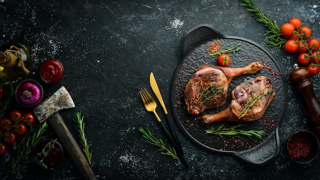 Gebakken eendendij met kruiden en rozemarijn Barbecuevlees Bovenaanzicht Platliggend bovenaanzicht op zwarte stenen snijtafel