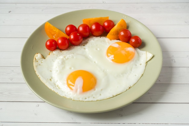 Gebakken eieren met cherrytomaten op een plaat