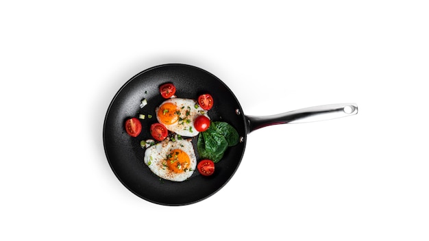Gebakken eieren met groenten op de pan geïsoleerd op een witte achtergrond. Prachtig ontbijt. Hoge kwaliteit foto