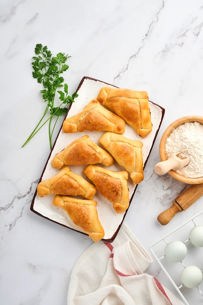 Gebakken empanadas met koriander, vlees, ei, tomaat en chilisaus op witte achtergrond. latijns-amerikaanse en chileense onafhankelijkheidsdag concept.