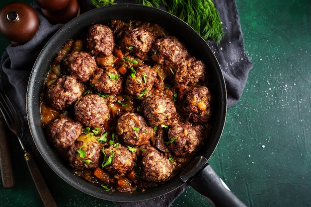 Gebakken gehaktballetjes met saus op pan