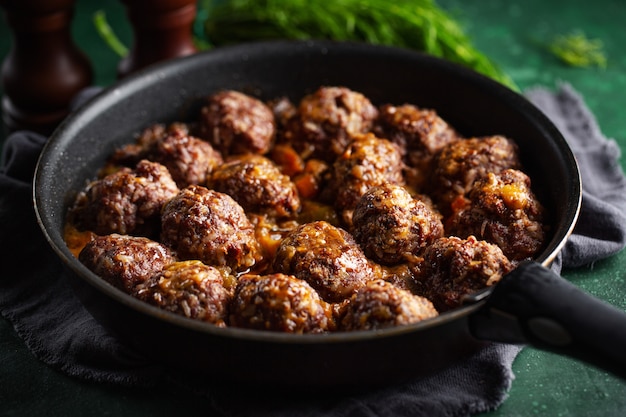 Gebakken gehaktballetjes met saus op pan