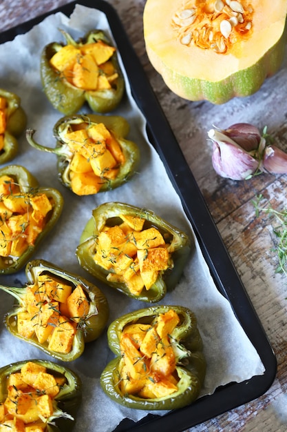 Gebakken groene paprika's gevuld met pompoen.