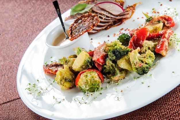 Gebakken groenten: broccoli, spruitjes, ui, tomaten en kruiden