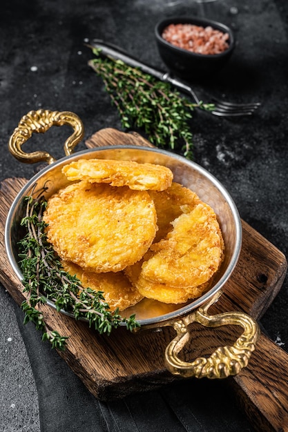 Gebakken Hash bruine aardappel hashbrown in een koekenpan Zwarte achtergrond Bovenaanzicht