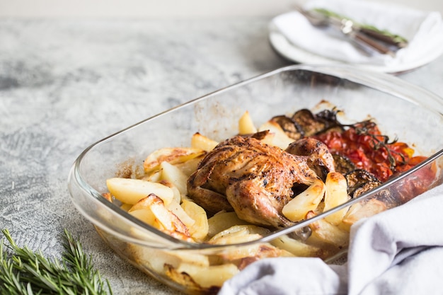 Gebakken hele kip met aardappelen, aubergine en kerstomaatjes. gezond diner