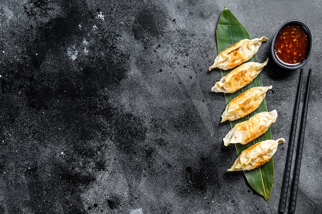 Gebakken Japanse gyoza dumplings. Zwarte ruimte. Bovenaanzicht. Kopieer ruimte