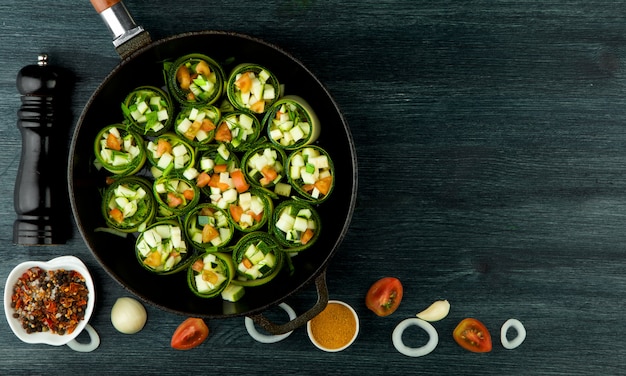 Gebakken jonge gesneden courgettes in een pan op een donkere ondergrond