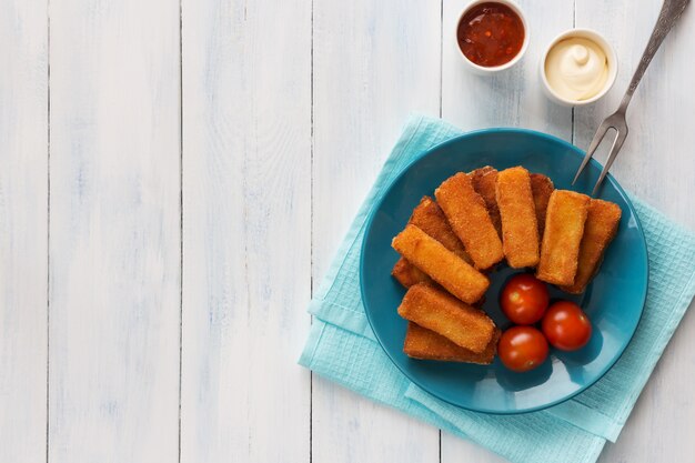 Gebakken kaassticks met tomaten en sauzen