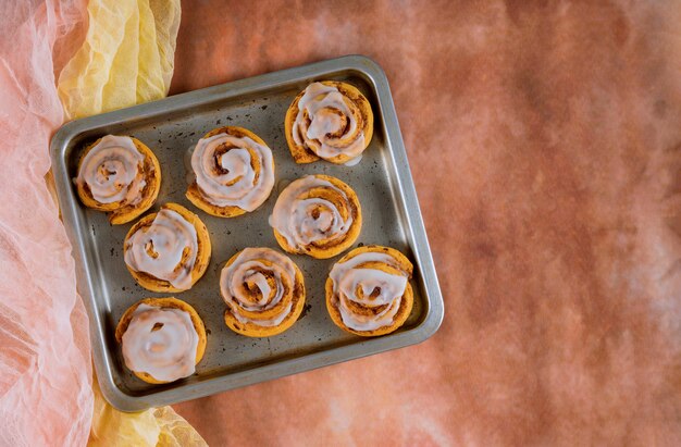 Gebakken kaneelbroodjes op stalen bakplaat.