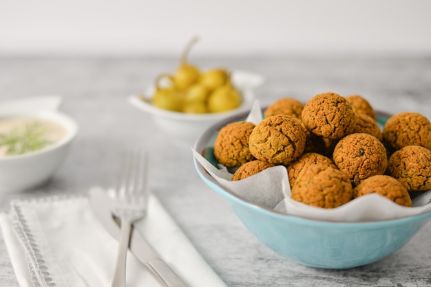 Gebakken kikkererwten falafel ballen op blauwe plaat op grijs, gezond en veganistisch eten met tahini diepe en hete peper, traditionele mediterrane, bovenaanzicht, plat leggen met kopie ruimte